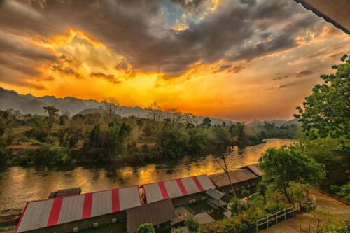 После грозы на реке Квай, заходящее солнце пробивается сквозь низкие кучевые облака